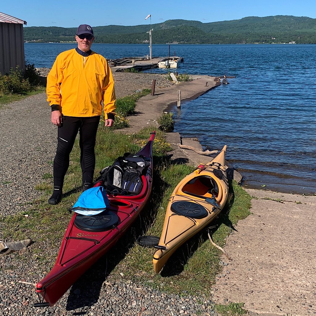 Richard with our kayaks at the dock on Grand Portage Bay. We completely ignored the wind sock showing strong off-shore winds building, bringing with it the possibility of a squall as warm air hit the cold of Lake Superior. 