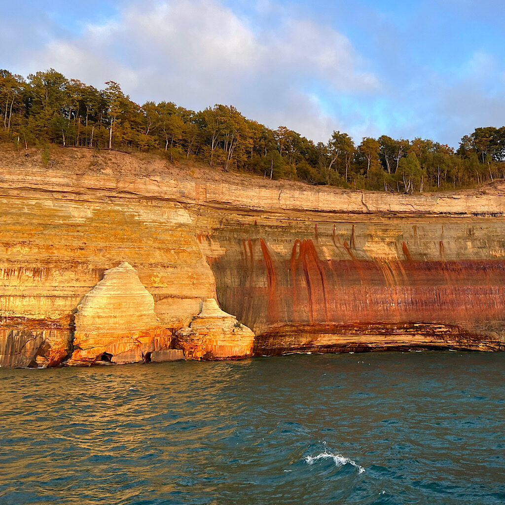 Orangey-red iron colors the sandstone cliffs of Pictured Rocks as if Jackson Pollack through a paint can at it. 