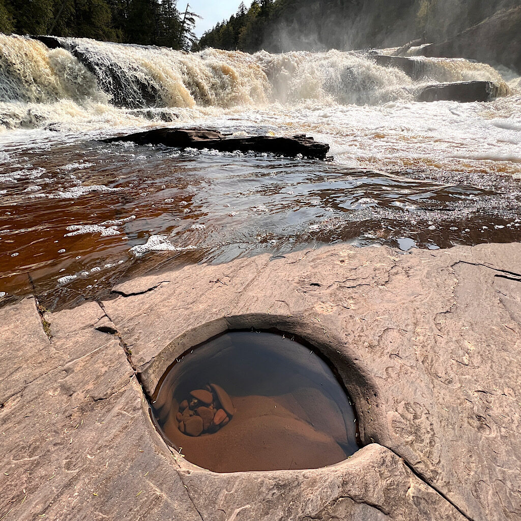 A hole drilled in less hard shale by the power of the Presque Isle River. 